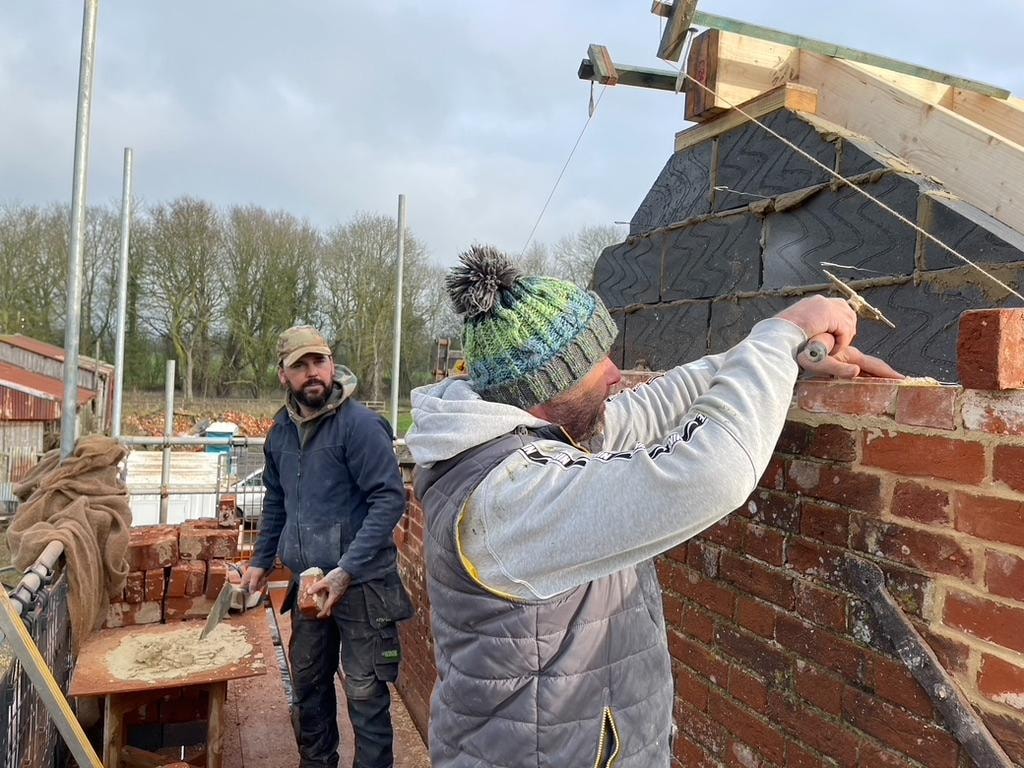 The Grain Barn — bricklayers laying the gable end, handcrafted brickwork on site