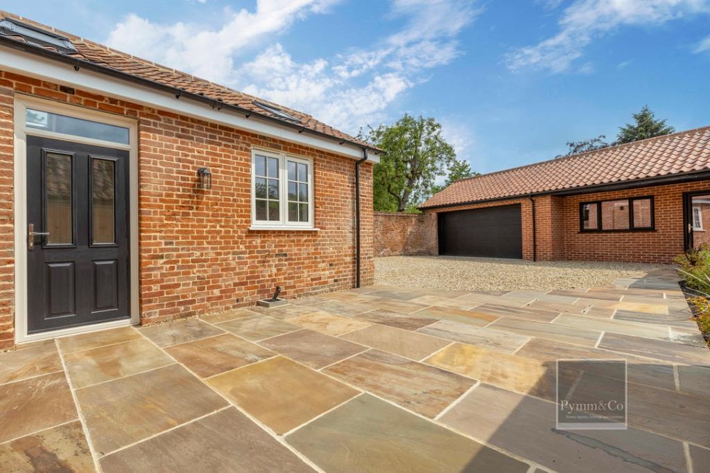 Malthouse refurbishment — sandstone patio, brick outbuilding and garage courtyard