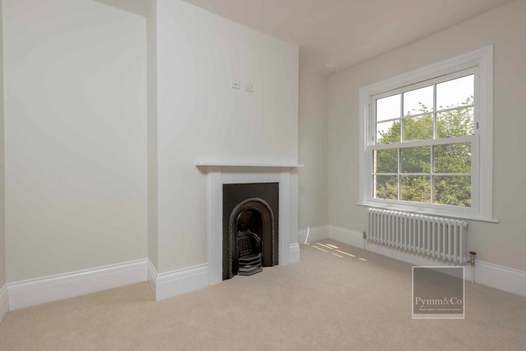 Malthouse refurbishment — bright reception room with period fireplace and sash window