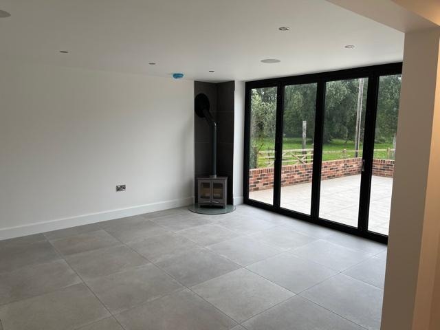The Nook — living room with log burner, bifold doors and garden view