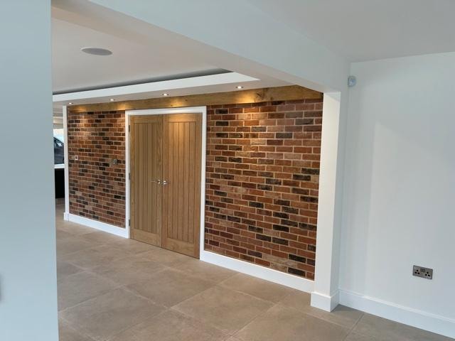 The Nook — exposed brick feature wall with oak beam and oak internal door